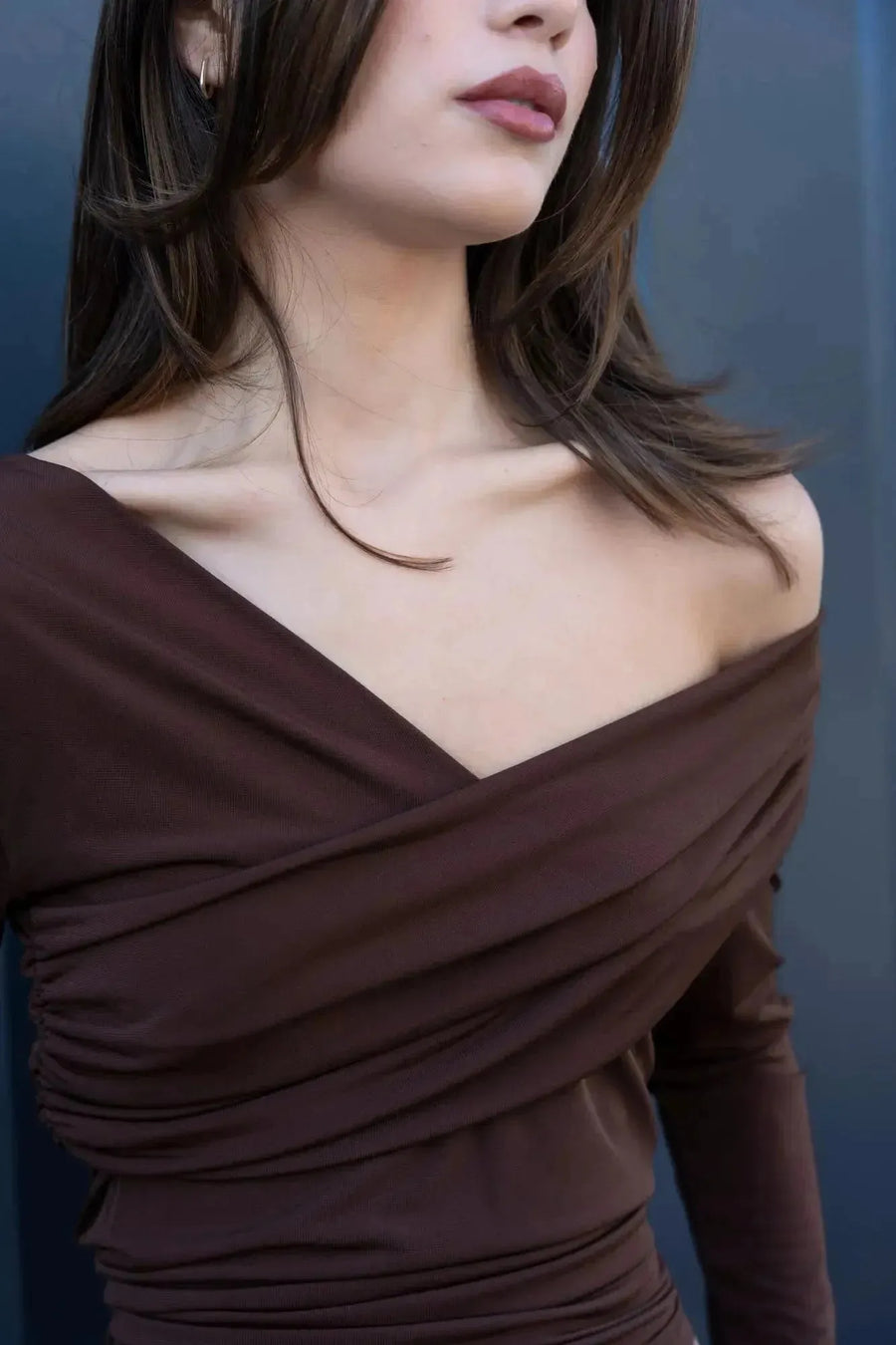 Détail d'une femme dans un T-shirt asymétrique brun, mettant en valeur le décolleté et la coupe flatteuse. T shirt asymétrique femme.