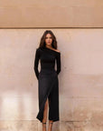 Femme portant un t-shirt asymétrique noir à manches longues et une jupe midi