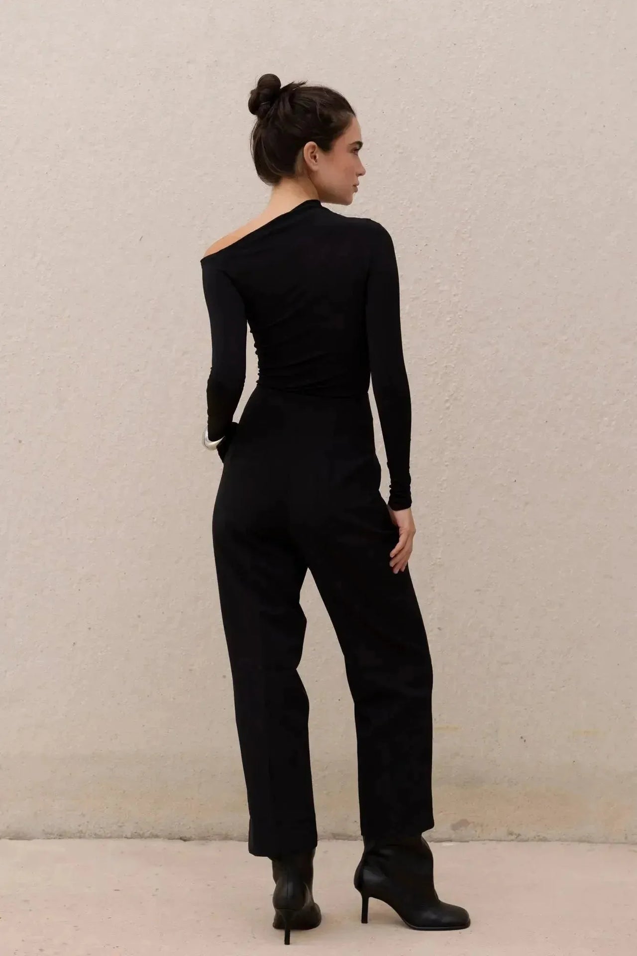 T-shirt asymétrique noir à manches longues avec pantalon large pour un look moderne