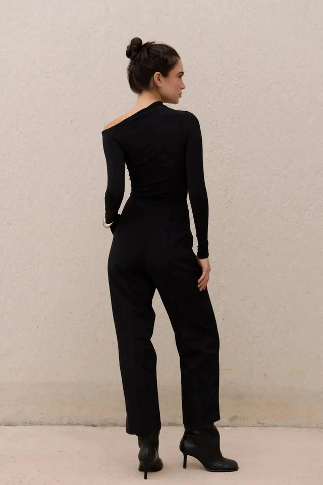 T-shirt asymétrique noir à manches longues avec pantalon large pour un look moderne