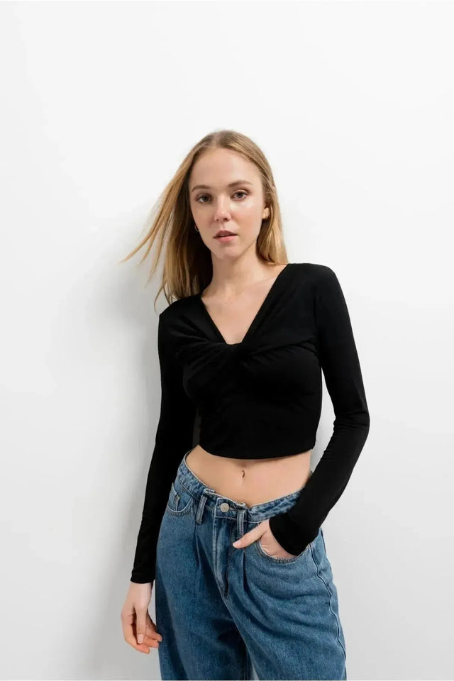 Modèle féminin dans un T-Shirt Crop Top Manche Longue Avec Noeud Élégant Pour Femme, décontracté et élégant, devant un fond épuré.