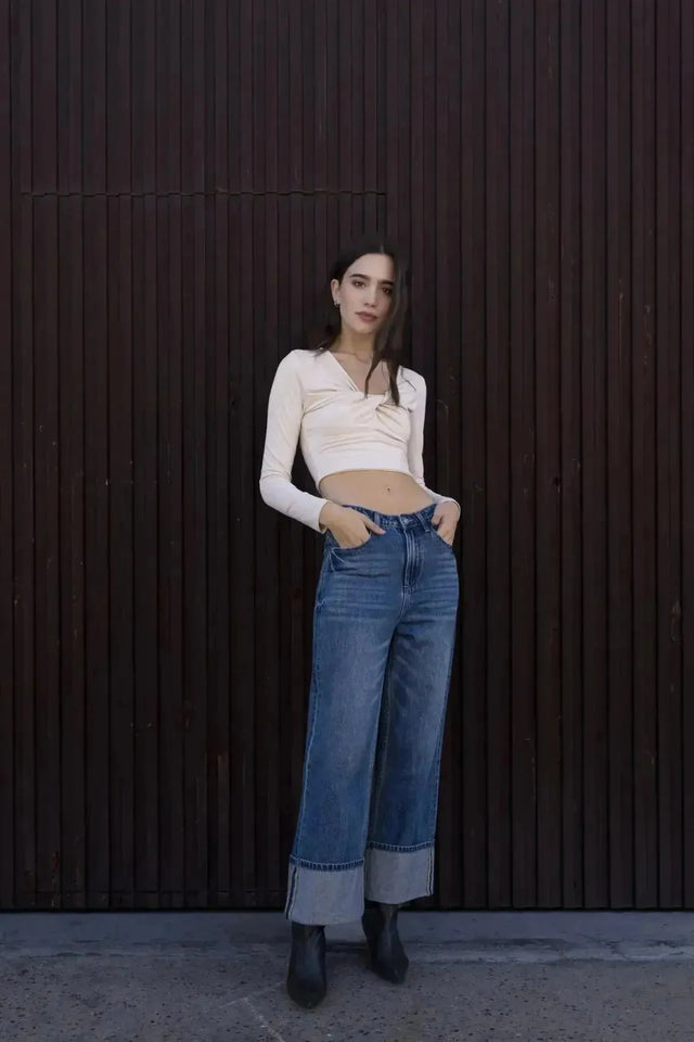 Vue d'une femme dans un T-Shirt Crop Top Manche Longue Avec Noeud Élégant Pour Femme, mettant en avant son style avec un jean tendance.