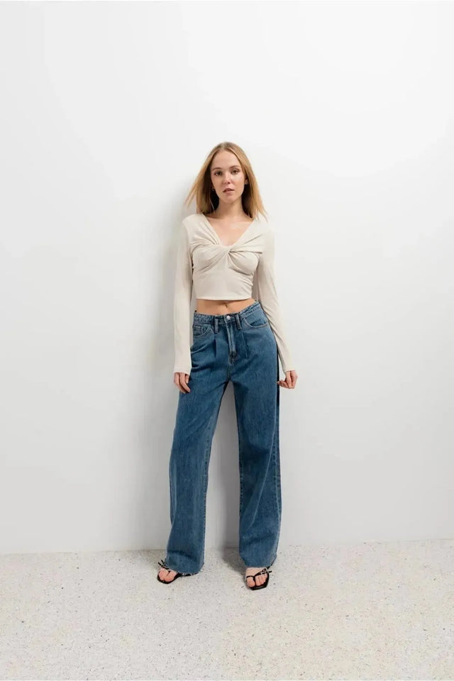 Femme souriante en T-Shirt Crop Top Manche Longue Avec Noeud Élégant Pour Femme, associée à un jean, idéale pour des occasions variées.