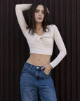 Modèle portant un T-Shirt Crop Top Manche Longue Avec Noeud Élégant Pour Femme, chic et confortable, harmonieusement associé à un jean.