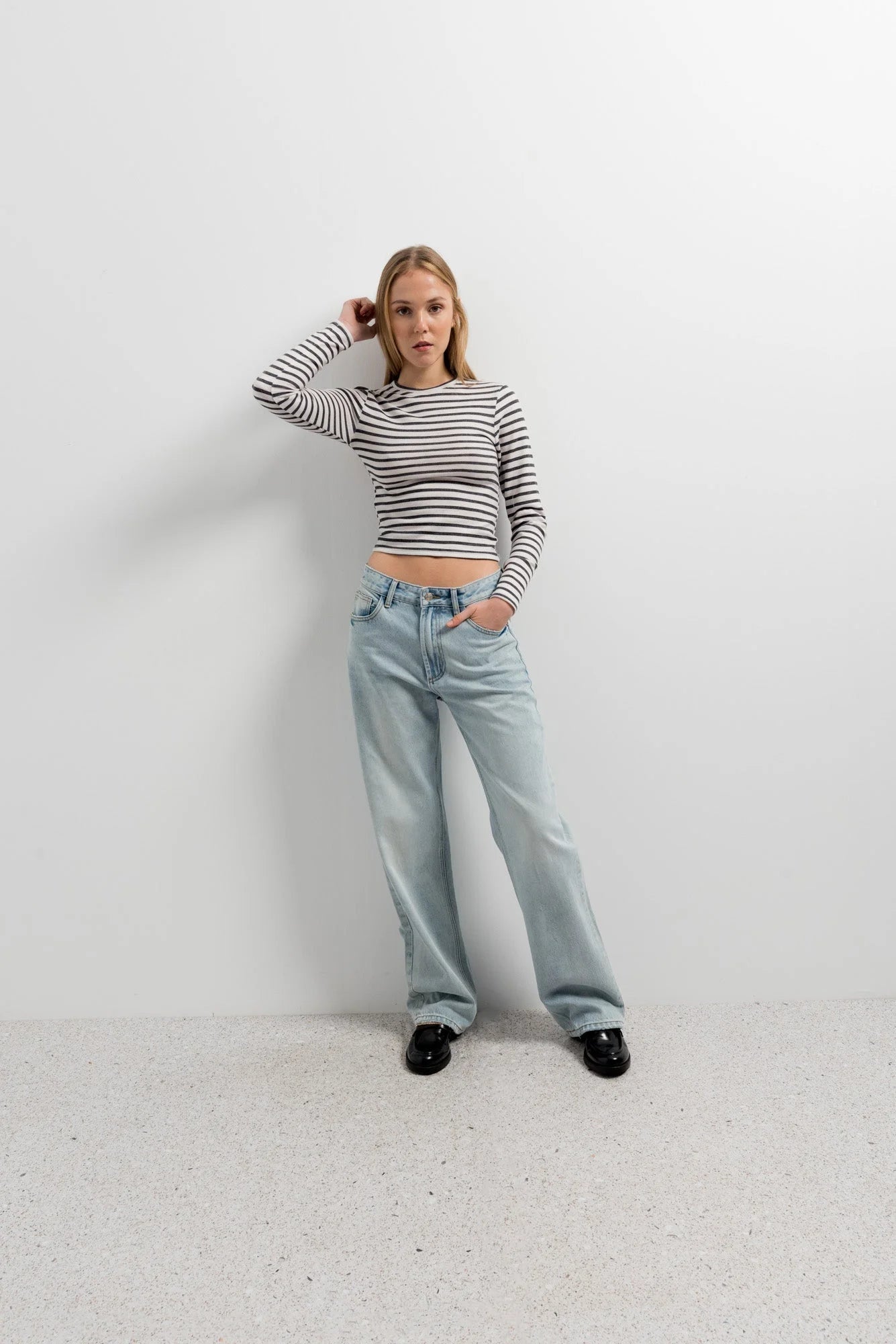 Femme portant un t-shirt marinière à manches longues et jeans décontractés