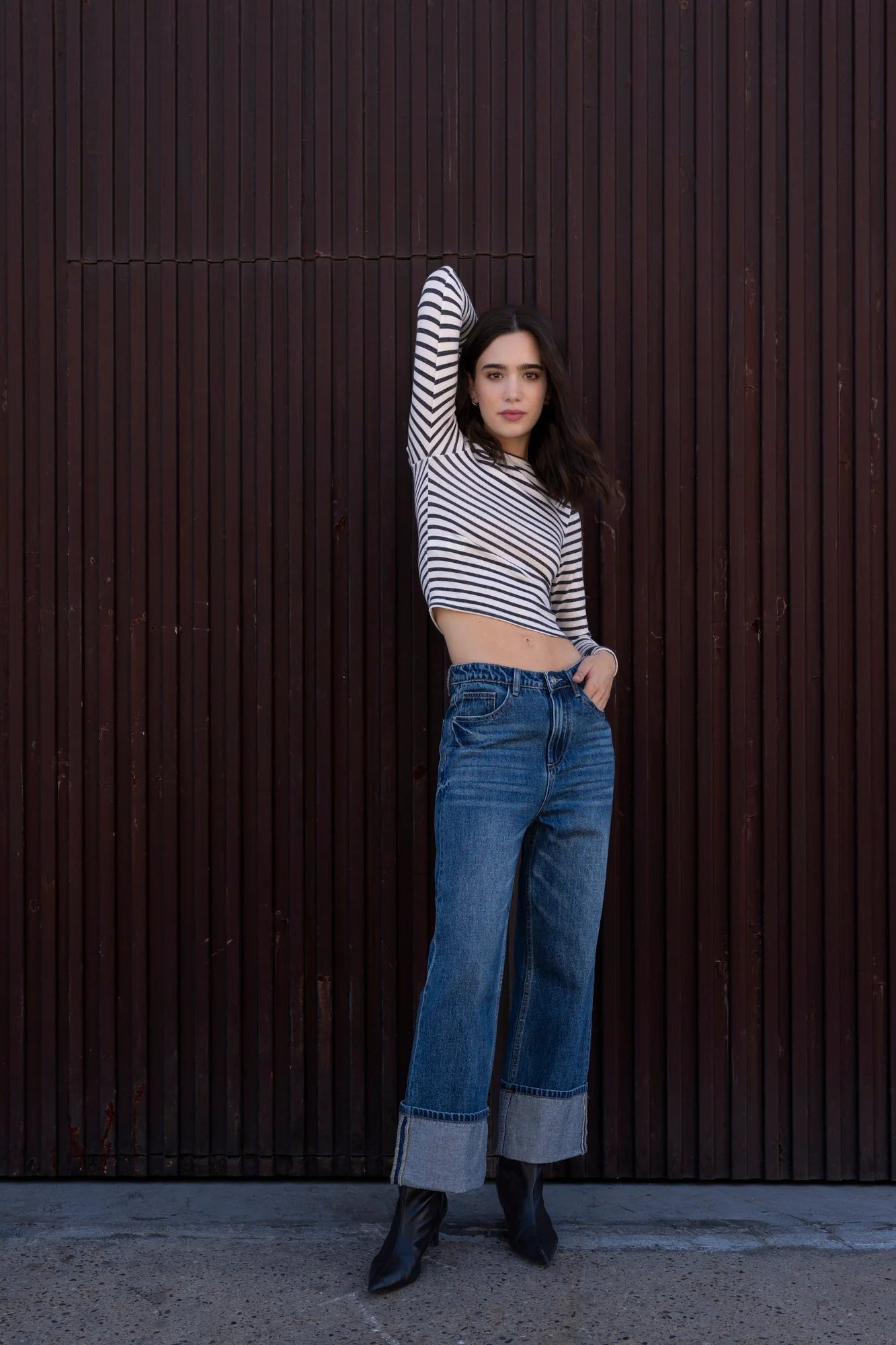 Femme en t-shirt marinière manches longues, jeans larges et bottines noires
