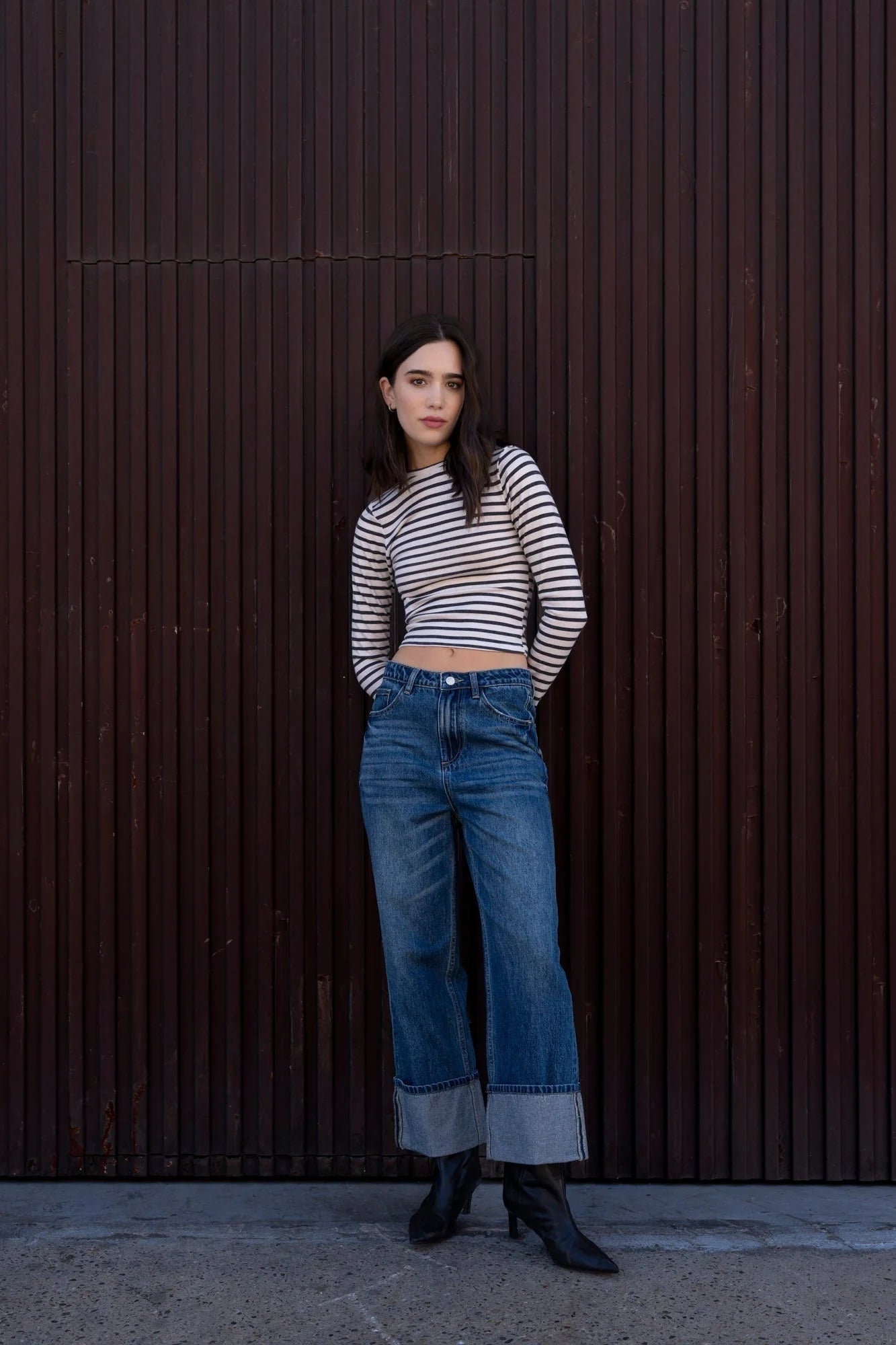 Femme en t-shirt marinière manches longues, jeans et bottines noires, look décontracté