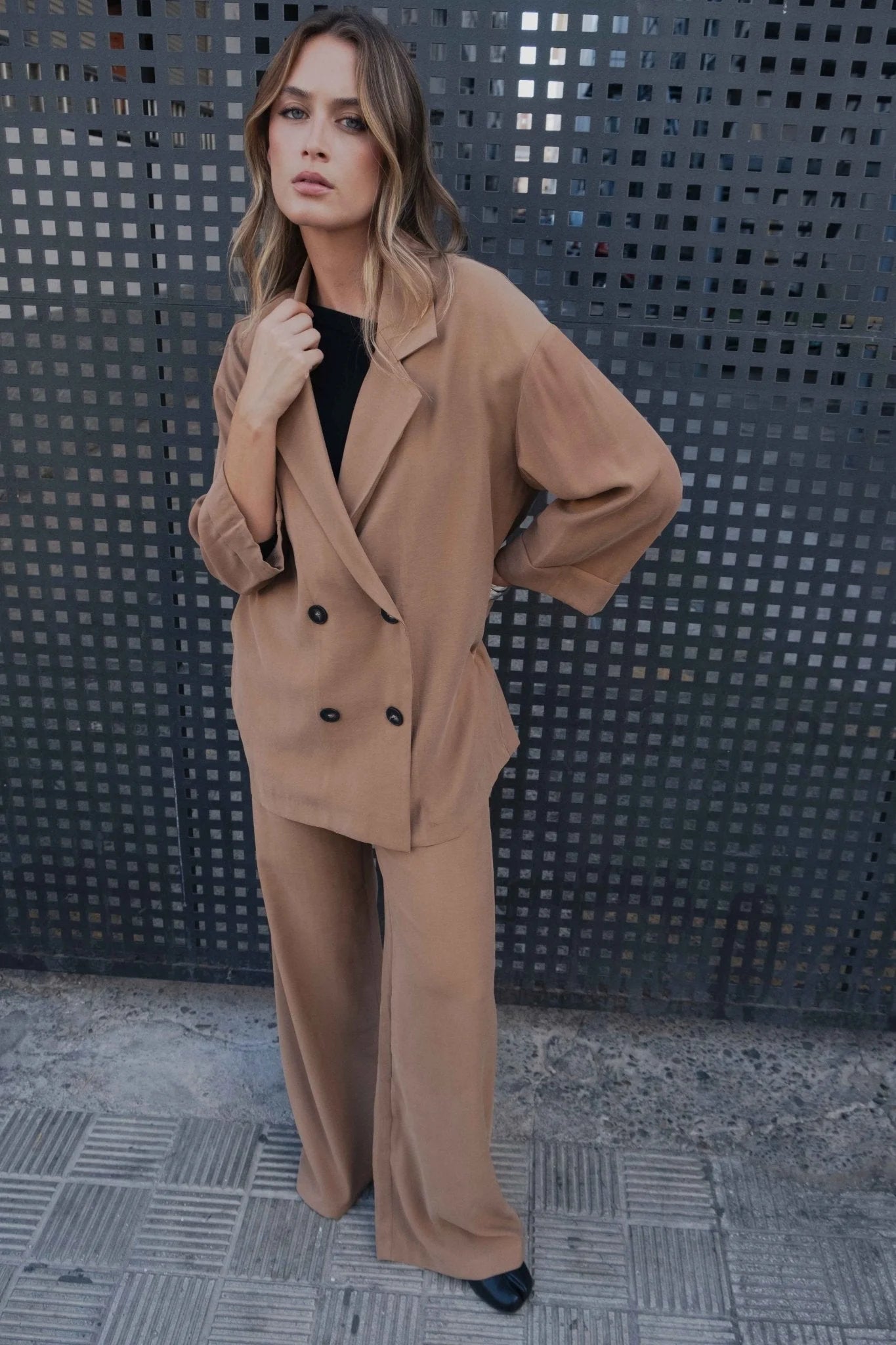 Femme portant un tailleur blazer oversize croisé fluide camel, costume ample et élégant