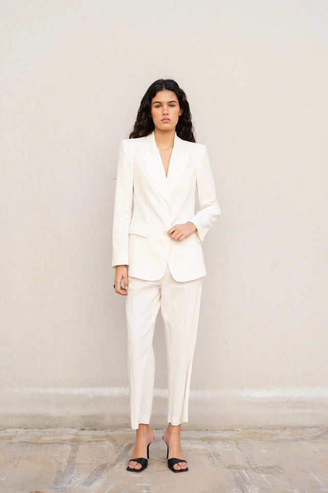 Modèle portant un blazer blanc femme en lin naturel, élégant et cintré pour l'été et mi-saison.