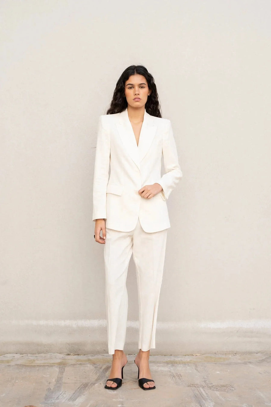 Modèle portant un blazer blanc femme en lin naturel, élégant et cintré pour l'été et mi-saison.