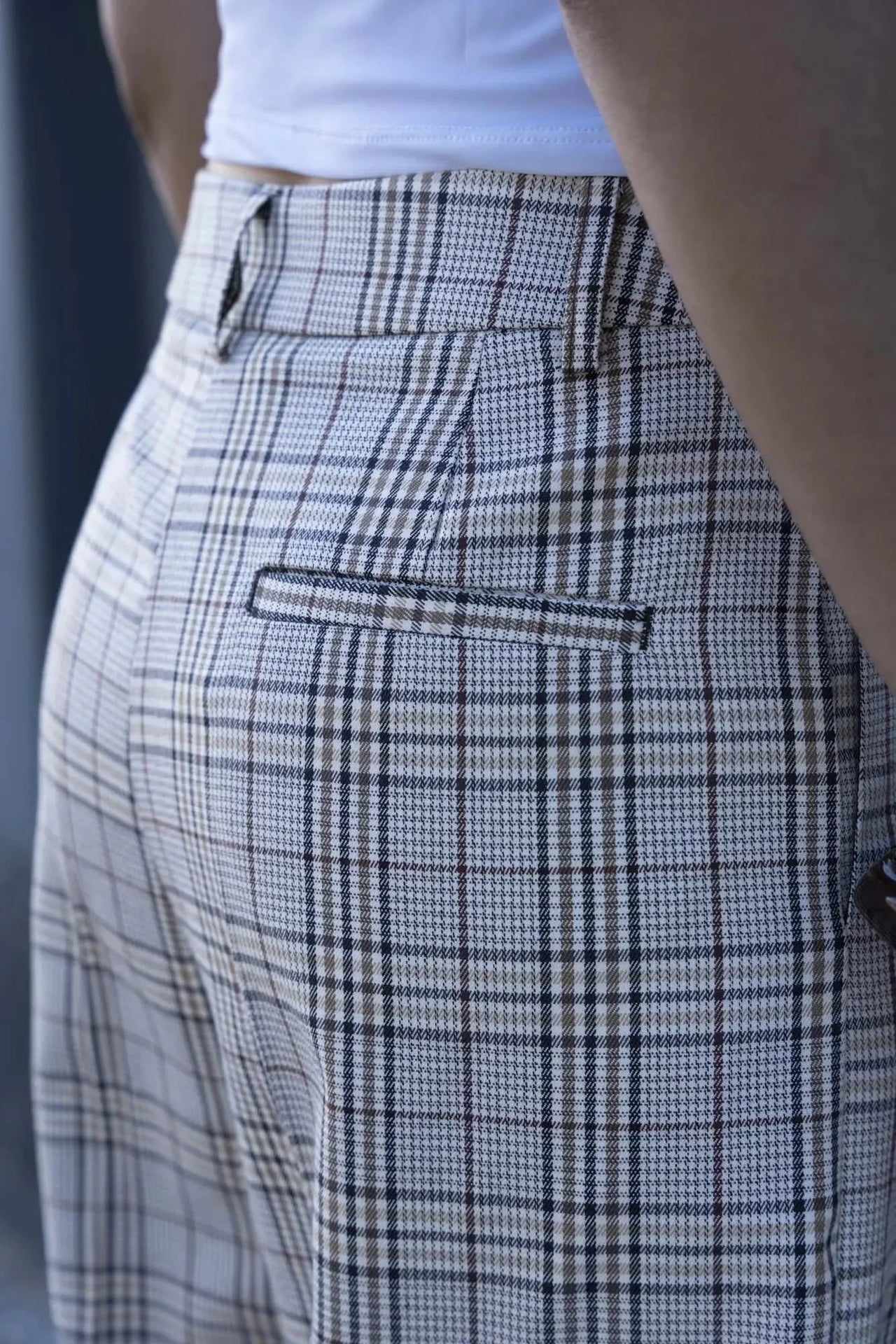 Gros plan sur le pantalon femme carreaux à motif beige, avec une coupe stylée et des détails élégants, montrant la qualité du design. Pantalon femme carreaux.