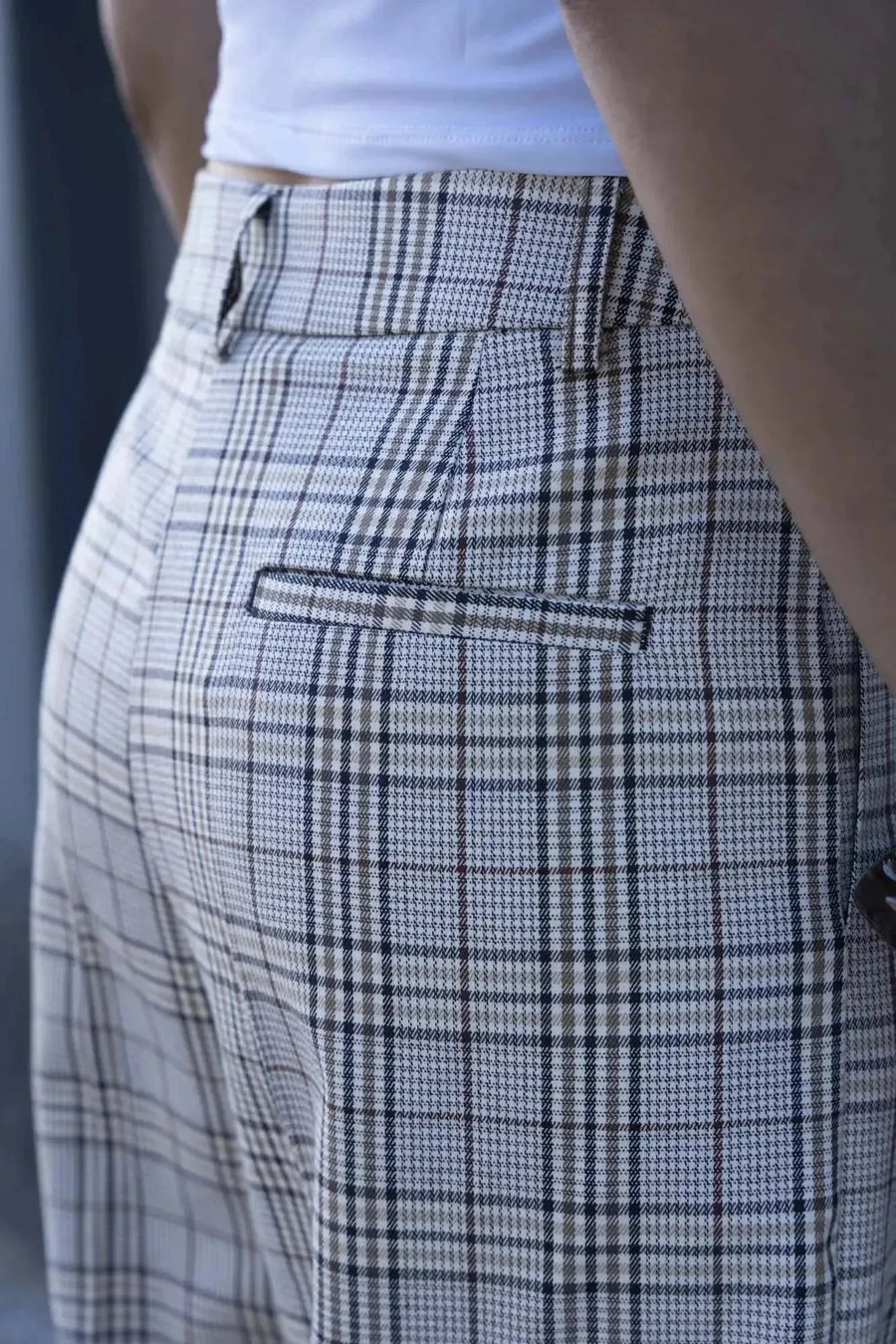 Gros plan sur le pantalon femme carreaux à motif beige, avec une coupe stylée et des détails élégants, montrant la qualité du design. Pantalon femme carreaux.