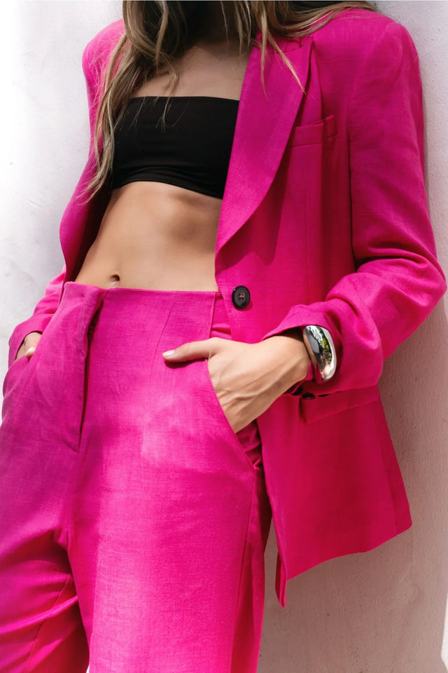 Détail d'un tailleur pantalon en lin rose fuchsia, blazer rose fuchsia femme, avec top noir.