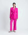 Look complet avec un pantalon femme mode lin rose fuchsia taille haute fluide et un blazer assorti, tenue élégante.