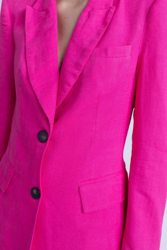 Femme de dos avec un tailleur pantalon en lin rose fuchsia, blazer rose fuchsia femme, style moderne.
