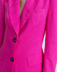 Femme de dos avec un tailleur pantalon en lin rose fuchsia, blazer rose fuchsia femme, style moderne.