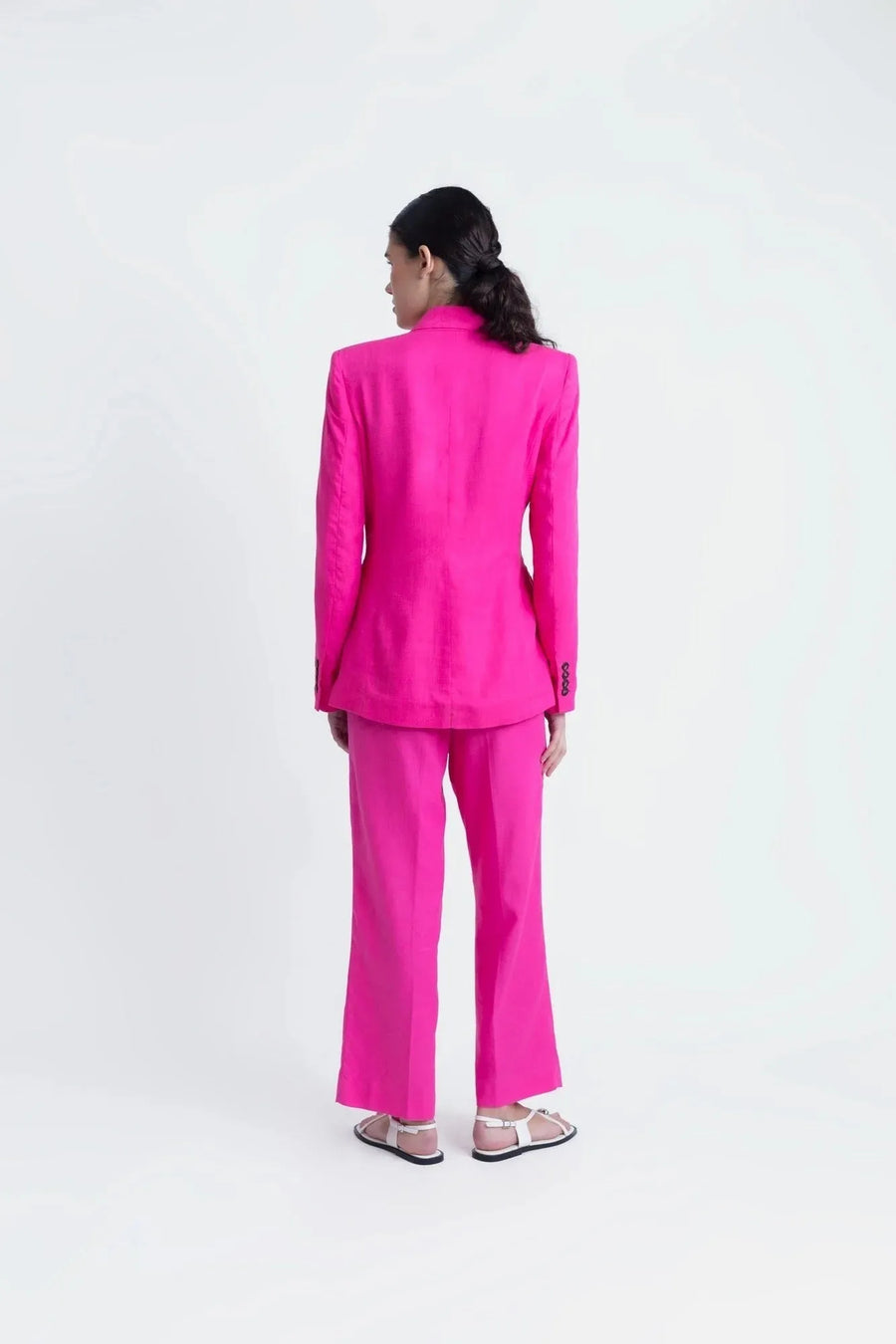 Vue arrière d'un tailleur pantalon en lin rose fuchsia, blazer rose fuchsia femme, élégance assurée.