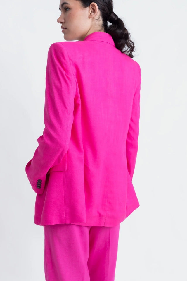 Détail sur le dos d'un tailleur pantalon en lin rose fuchsia, blazer rose fuchsia femme, avec coupe raffinée.