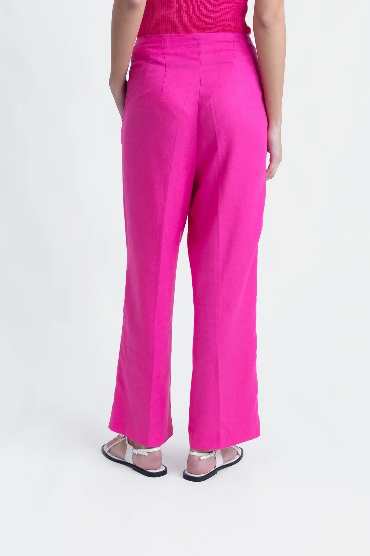 Vue arrière d'un pantalon femme mode lin rose fuchsia taille haute fluide, mettant en valeur la coupe élégante.