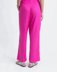 Vue arrière d'un pantalon femme mode lin rose fuchsia taille haute fluide, mettant en valeur la coupe élégante.