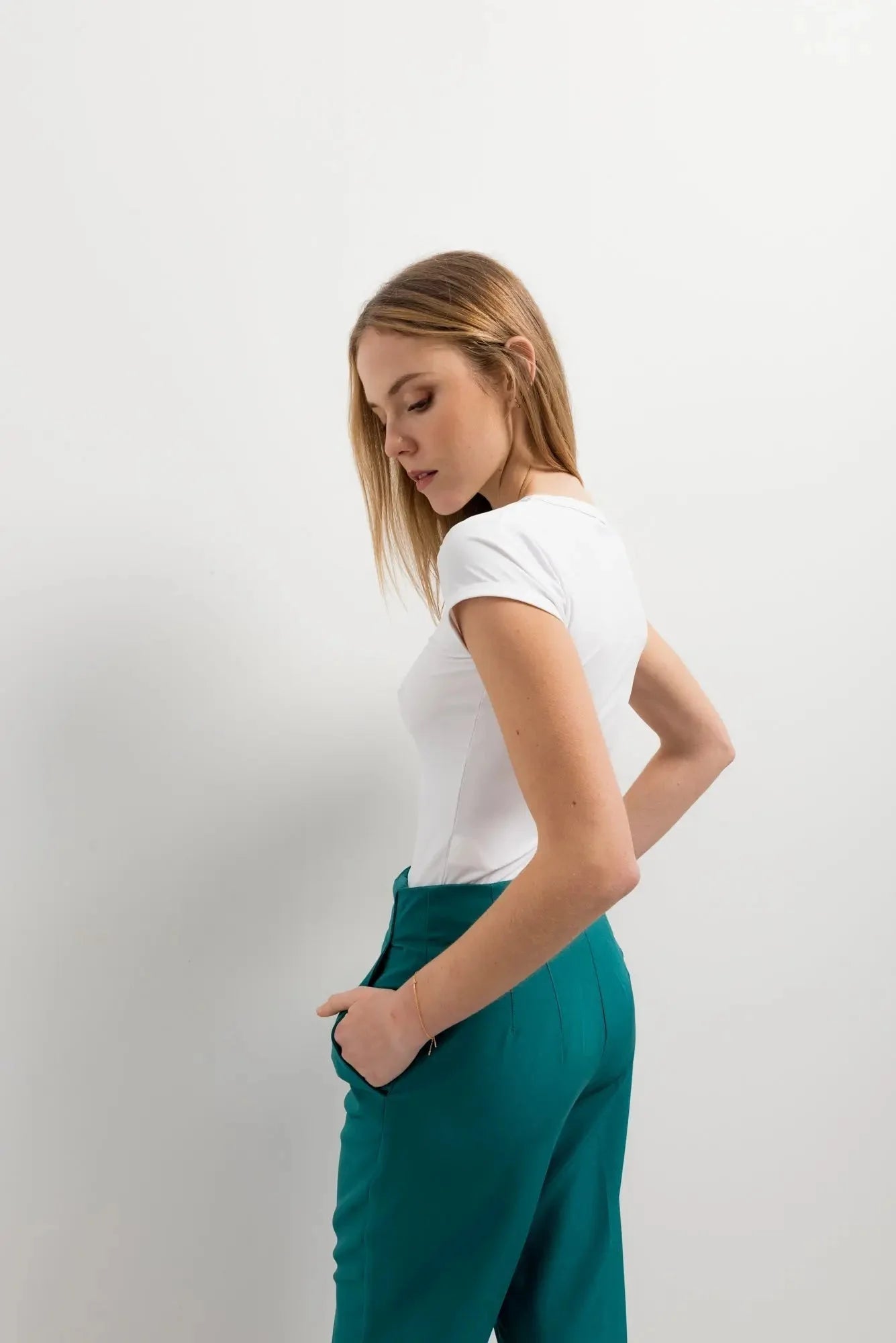 Femme portant un pantalon taille haute sarcelle dans un tailleur pantalon large taille haute