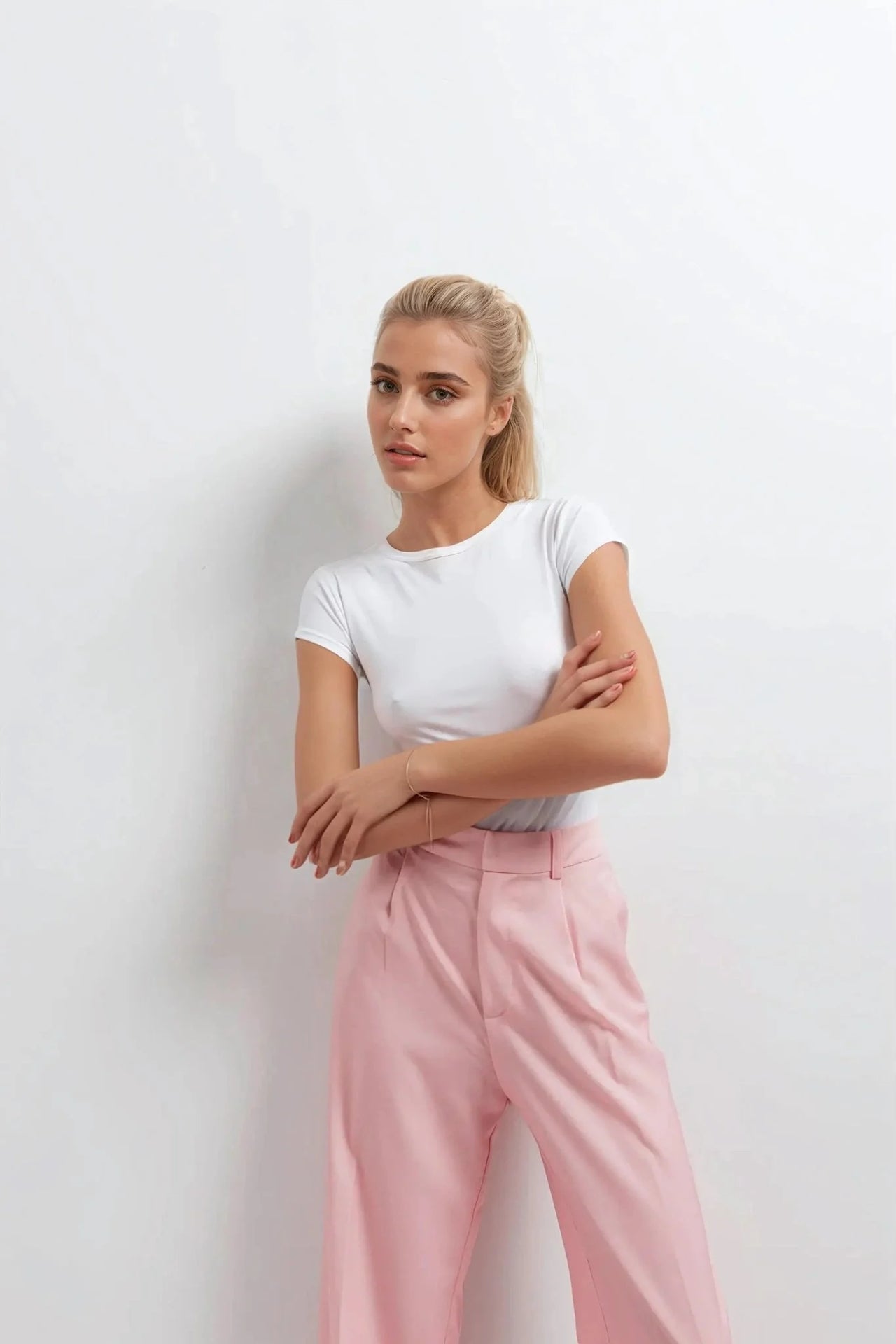 Pantalon rose femme ceinturé pour toutes occasions, femme portant un haut blanc et un pantalon rose, style décontracté mais élégant.