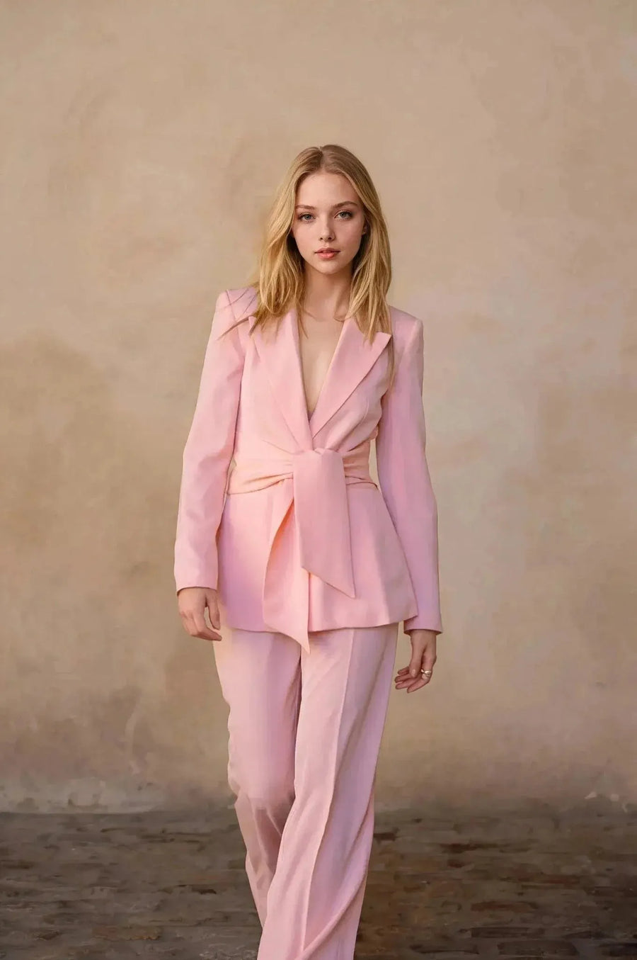 Pantalon rose femme ceinturé pour toutes occasions, femme marchant avec assurance dans une tenue chic et moderne.