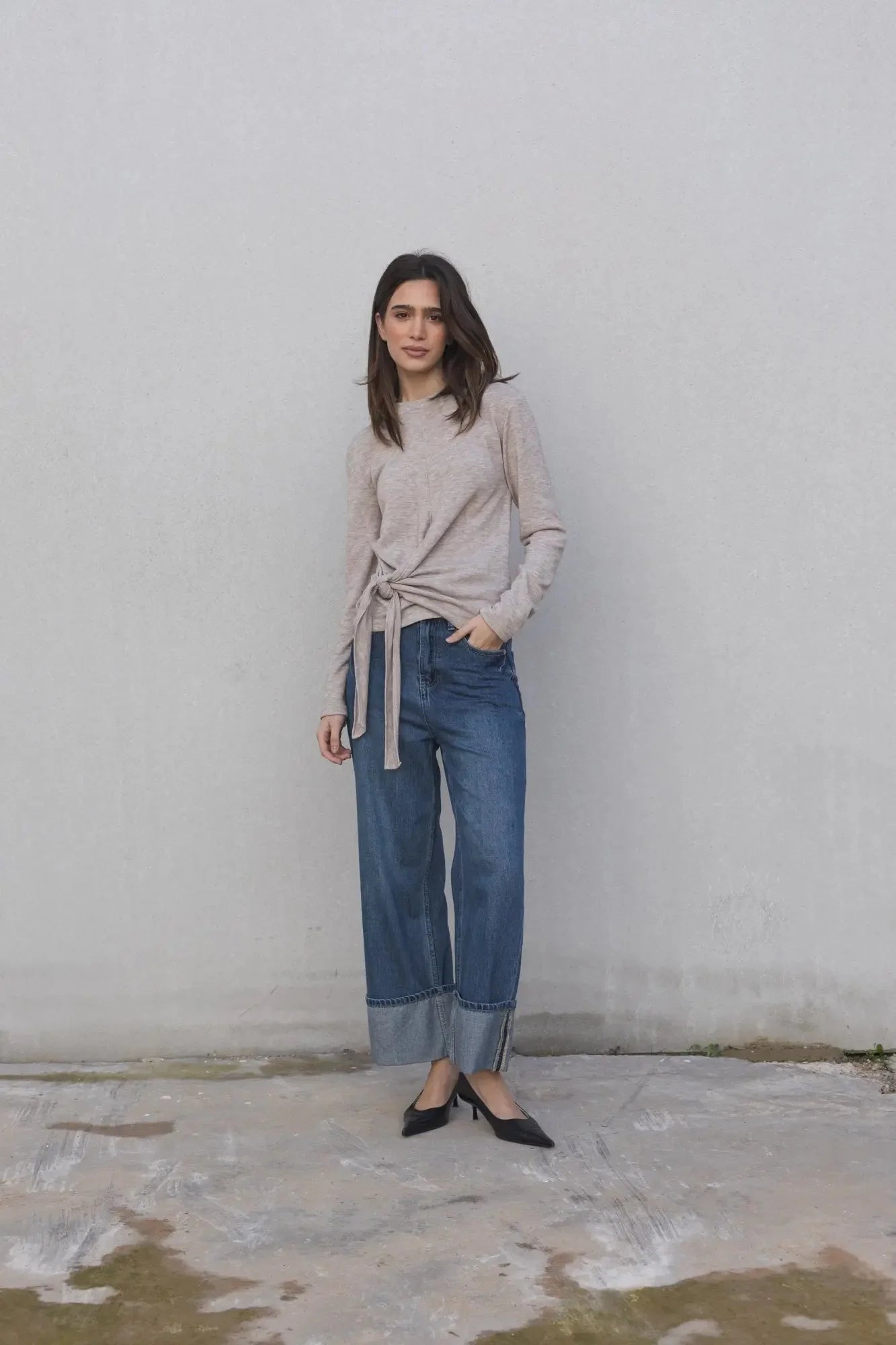 Femme portant un tee shirt beige femme à nouer manches longues avec un pantalon en jean, pour un style décontracté, élégant et confortable.