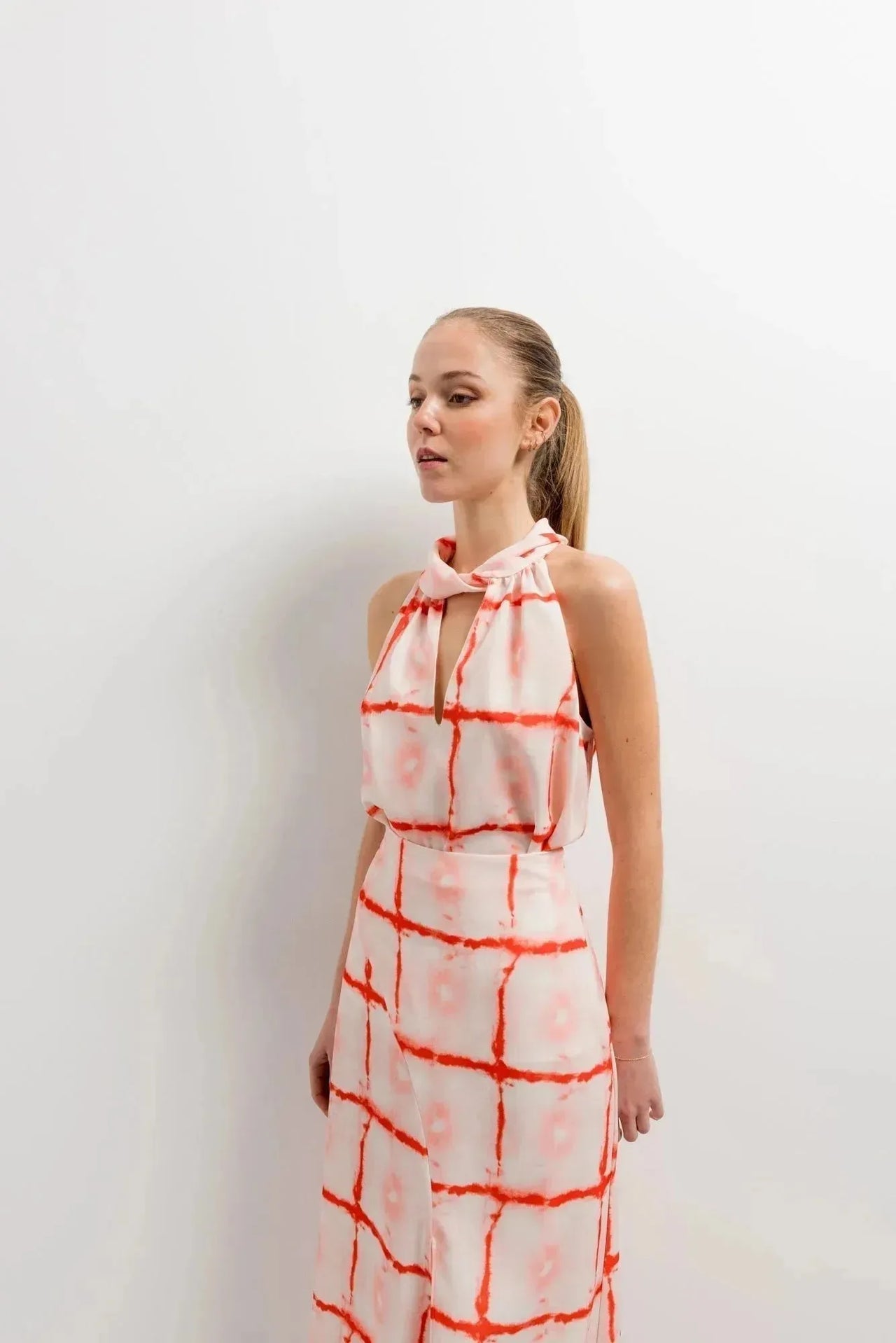 Femme en Top Col Halter Imprimé Graphique Rouge Et Blanc, montrant le look stylé et décontracté, parfait pour diverses occasions.