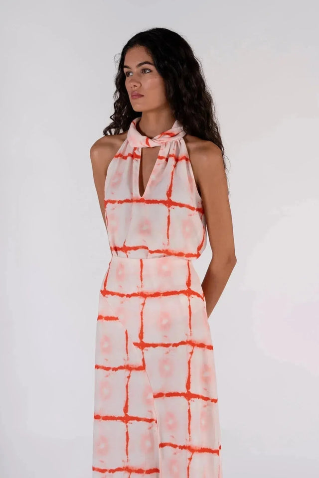 Femme debout avec le Top Col Halter Imprimé Graphique Rouge Et Blanc, présentant le col haut et le motif, idéal pour des occasions variées.