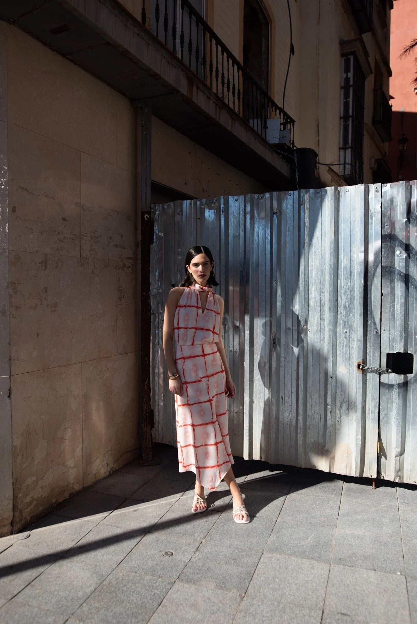 Femme portant un top à motifs géométriques rouge avec col noué et coupe fluide