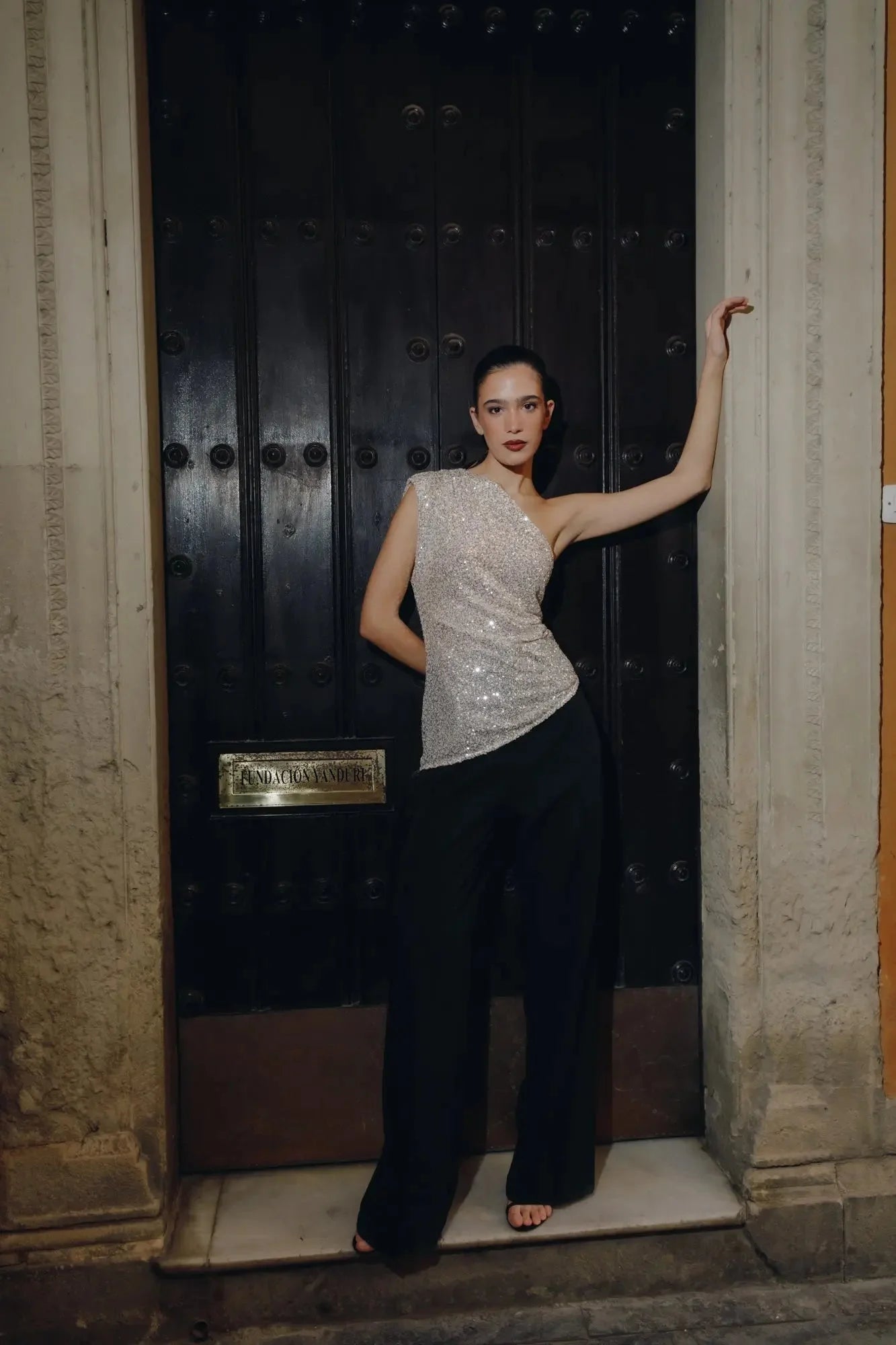 Femme portant un top asymétrique à paillettes argentées aux plus élégantes