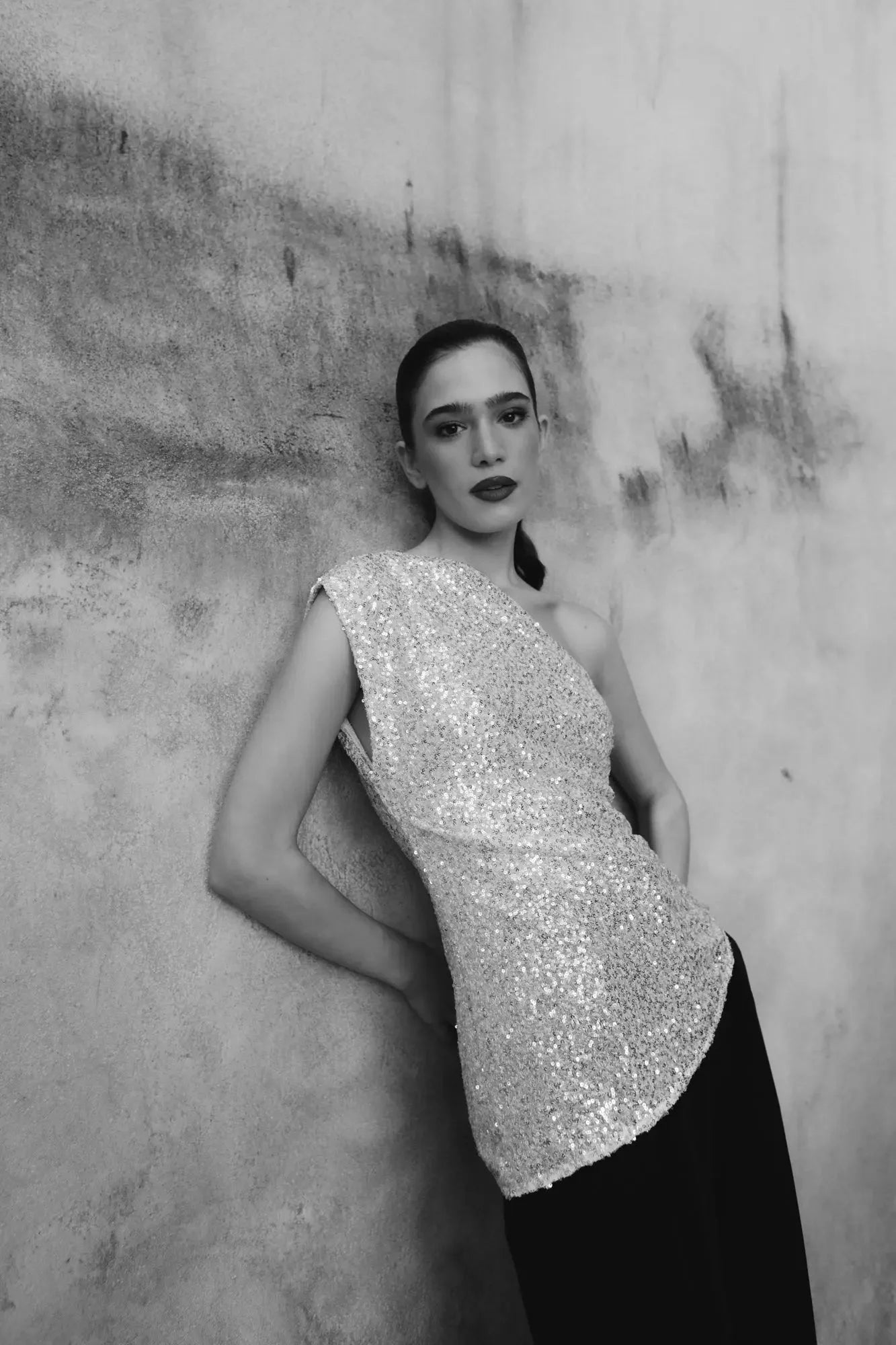 Femme portant un top asymétrique à paillettes argentées aux plus élégantes et modernes