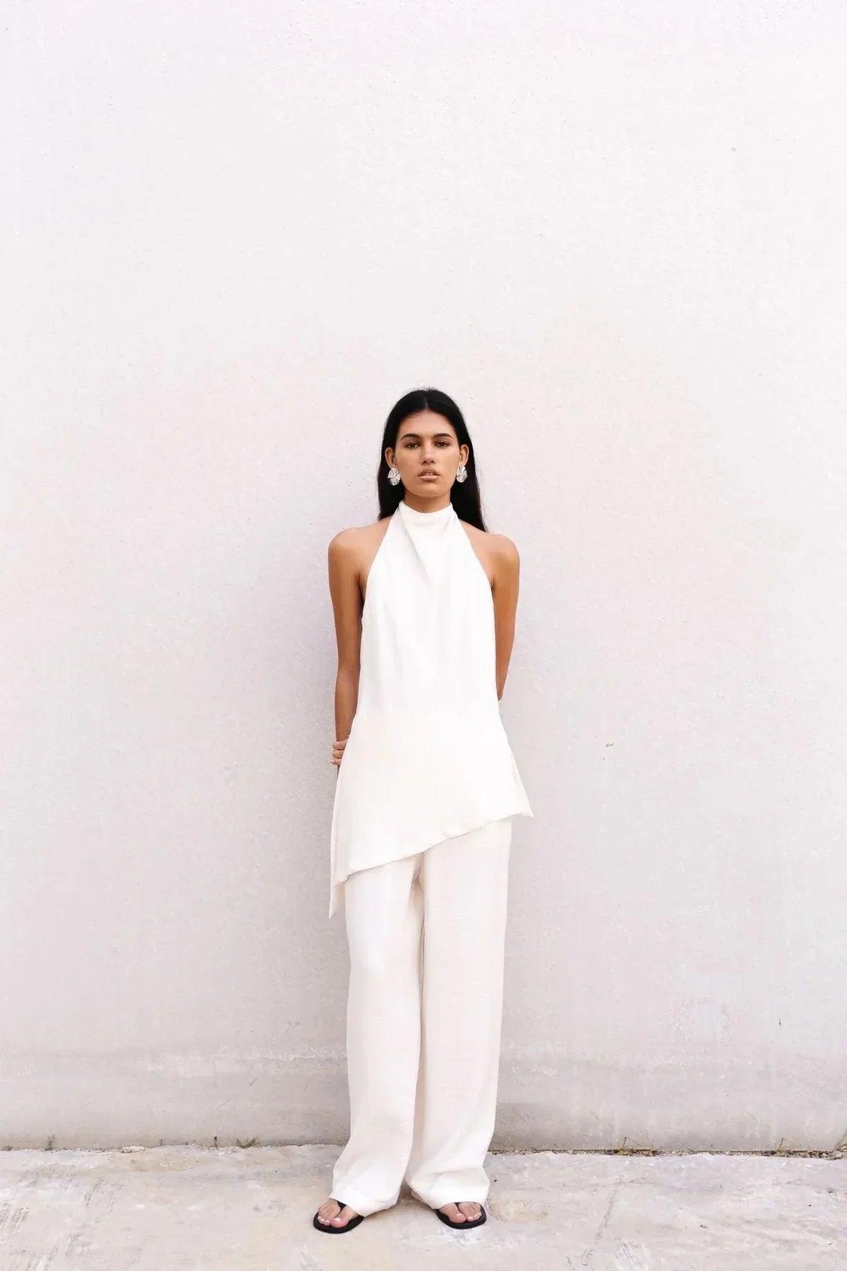 Femme portant un top asymétrique blanc chic à coupe fluide et col montant
