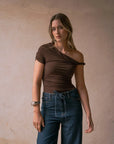 Femme portant un top asymétrique marron au design unique et look décontracté