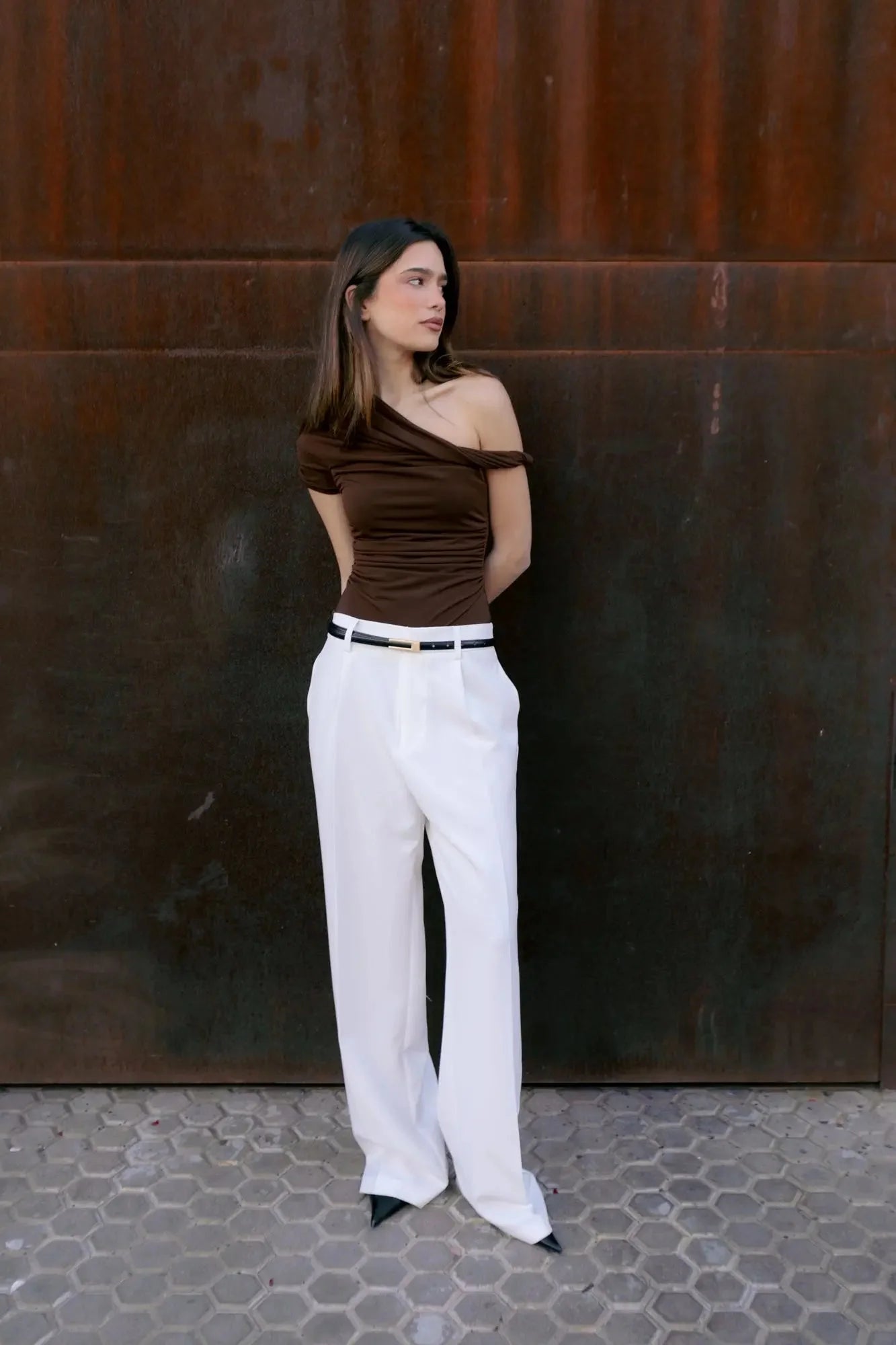 Femme portant un top asymétrique marron au design unique et look décontracté