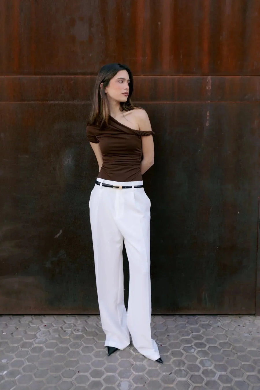 Femme portant un top asymétrique marron au design unique et look décontracté