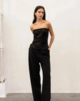 Femme portant un top bandeau femme noir élégant, le top paillette noir brillamment assorti à un look sophistiqué avec un pantalon noir.