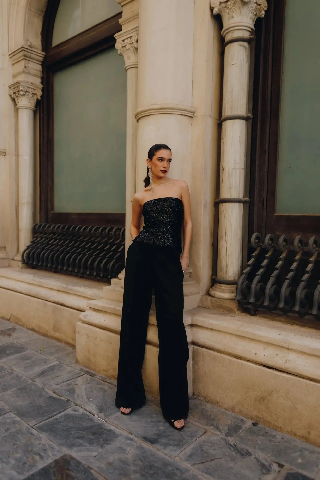 Femme portant un top bandeau femme noir élégant en haut, pantalon large noir