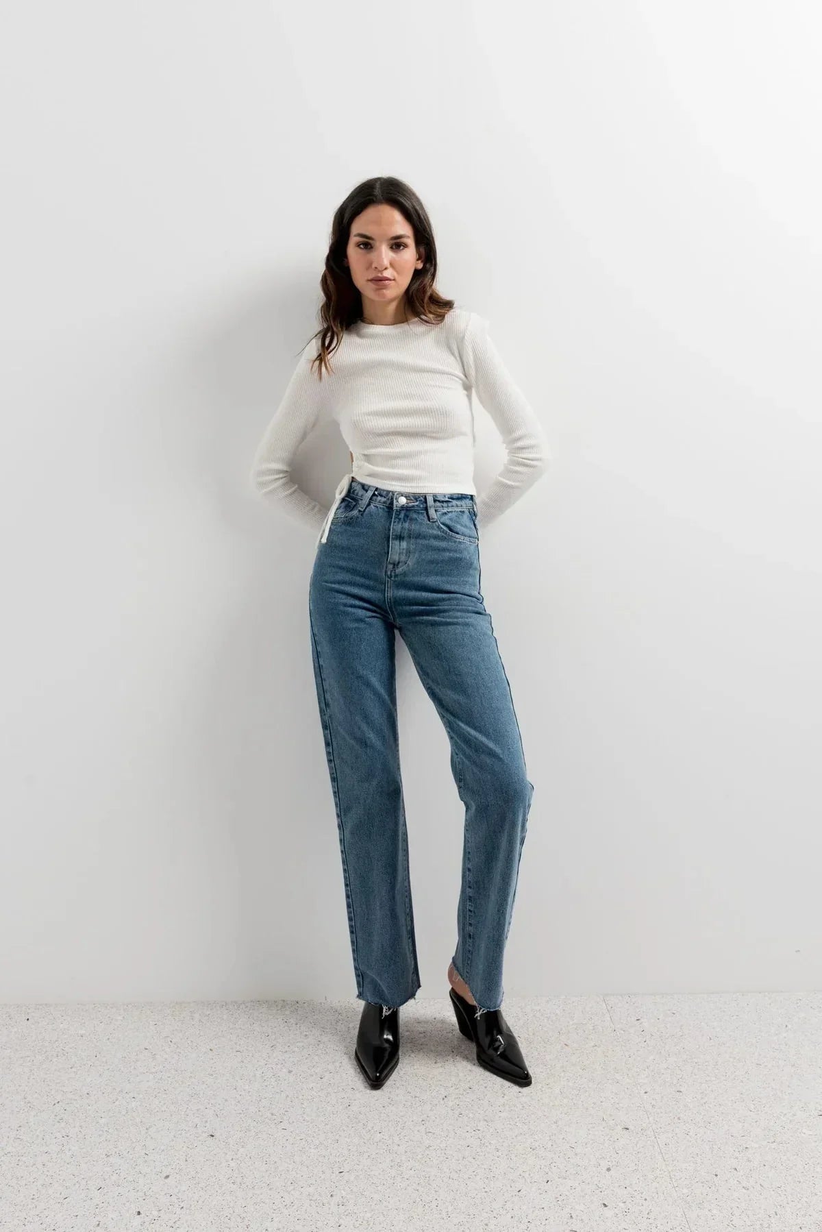 Femme portant un Top blanc côtelé à manches longues avec rassemblement latéral et jeans