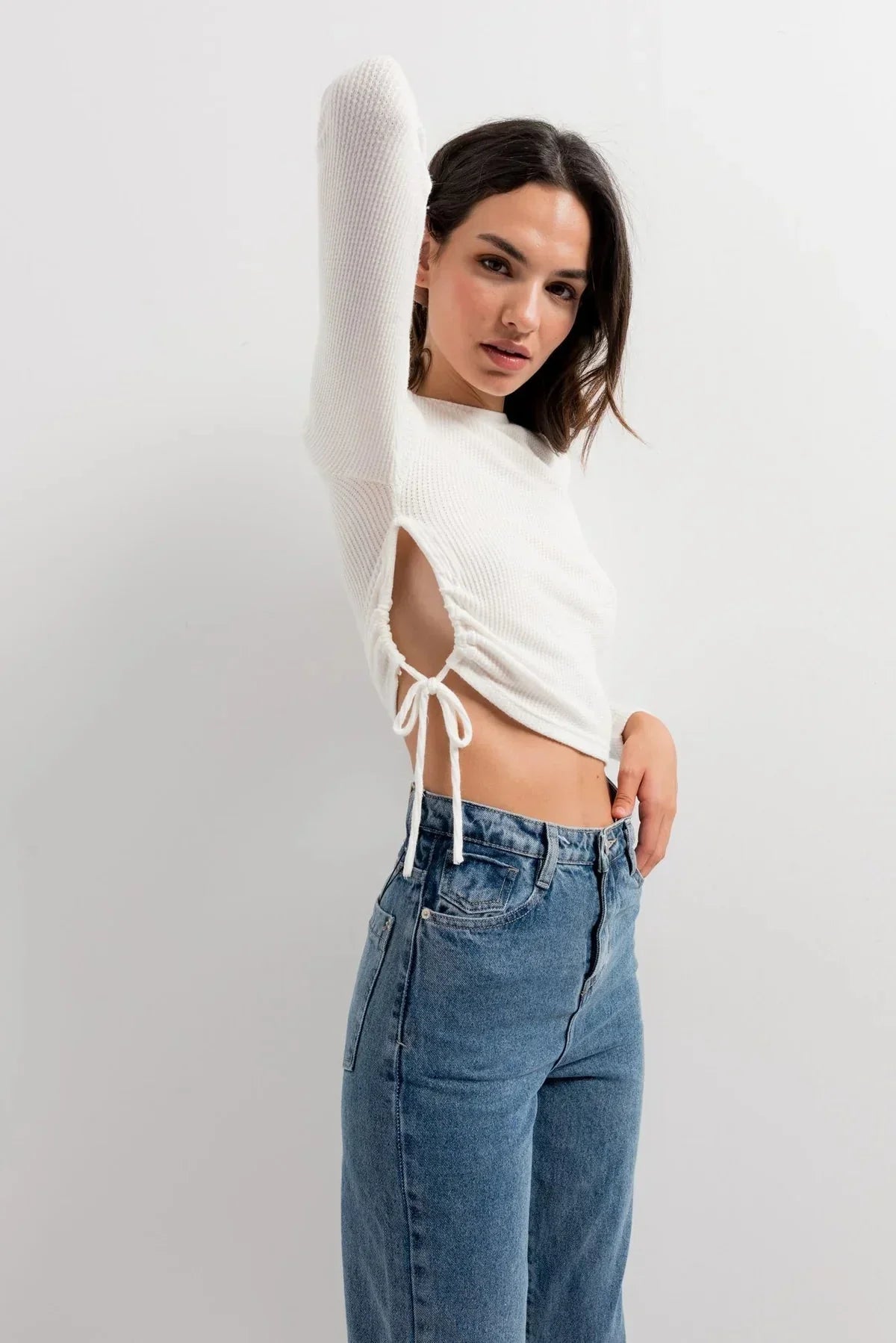 Top blanc côtelé à manches longues avec rassemblement latéral ajustable pour un look tendance