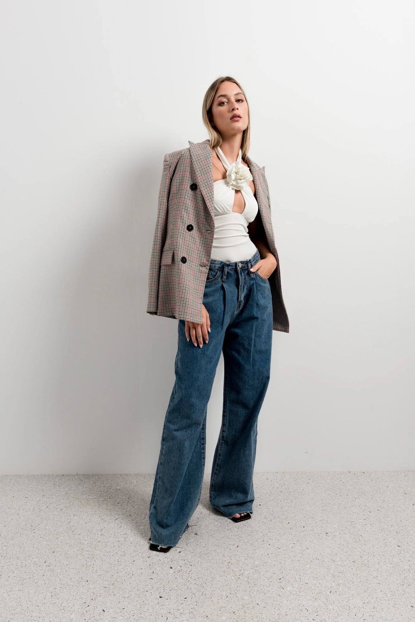 Femme portant un top blanc femme élégant à col noué floral et blazer à carreaux