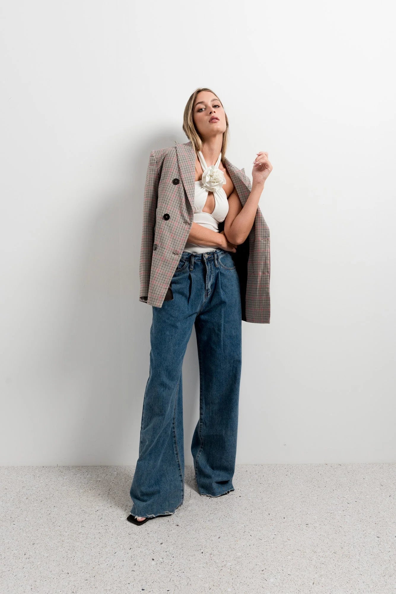 Femme portant un top blanc femme élégant à col noué floral avec blazer beige et jeans
