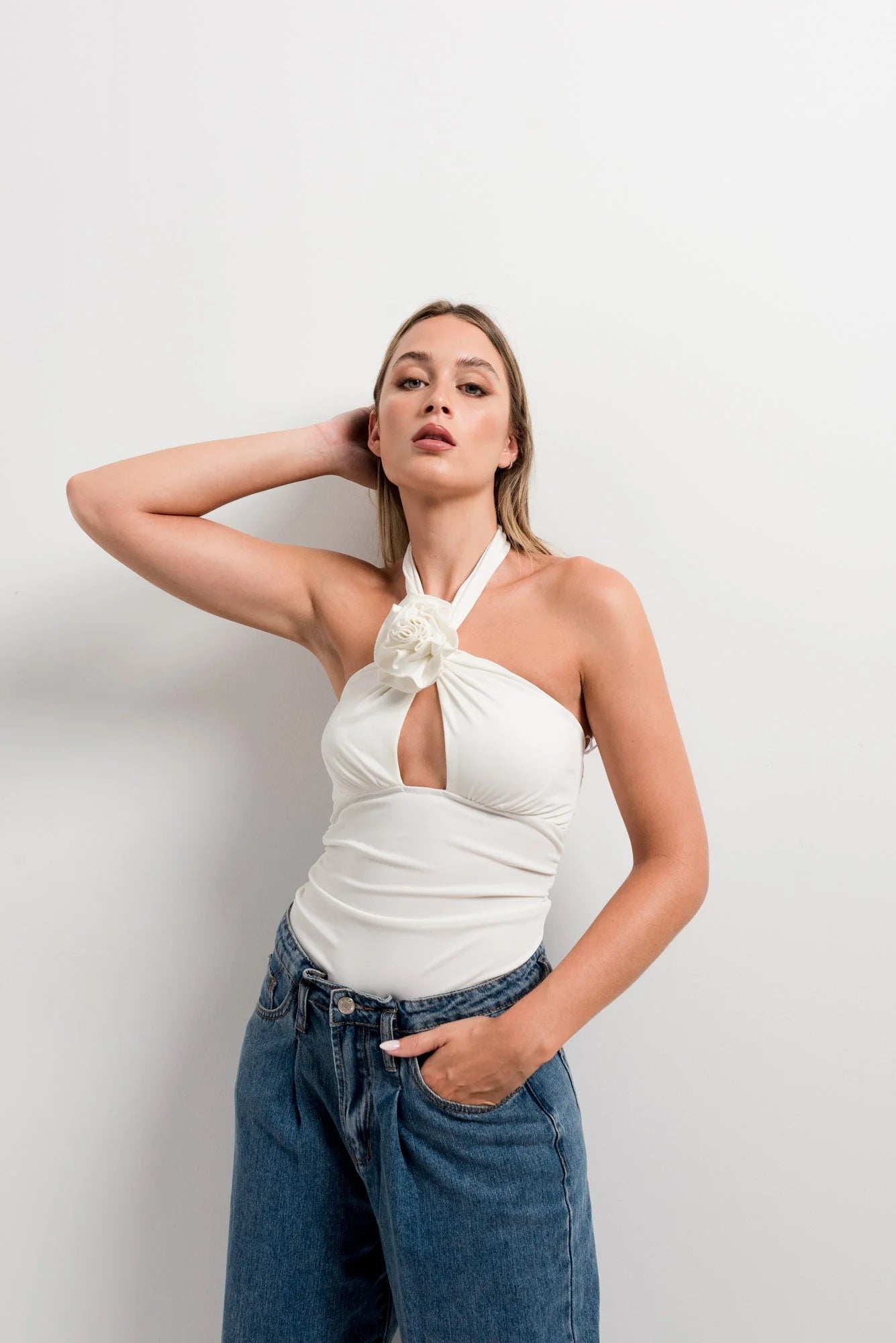 Top blanc femme élégant à col noué avec embellissement floral et découpe en clé