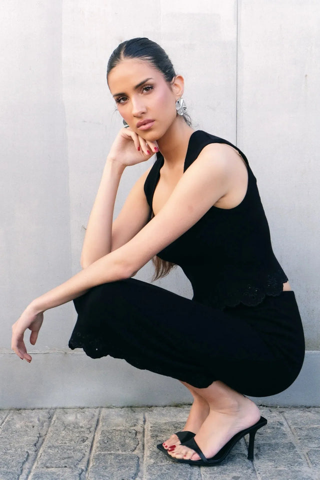 Top élégant soirée – Style minimaliste ajusté – Noir – Encolure carrée, modèle accroupi, montrant le haut noir femme chic en détail.