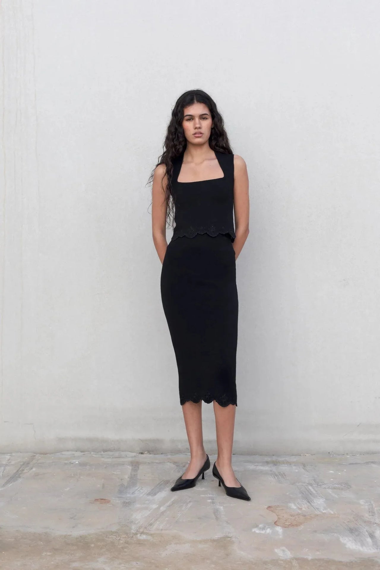 Top élégant soirée – Style minimaliste ajusté – Noir – Encolure carrée, modèle debout montrant le haut noir femme chic, attitude élégante.