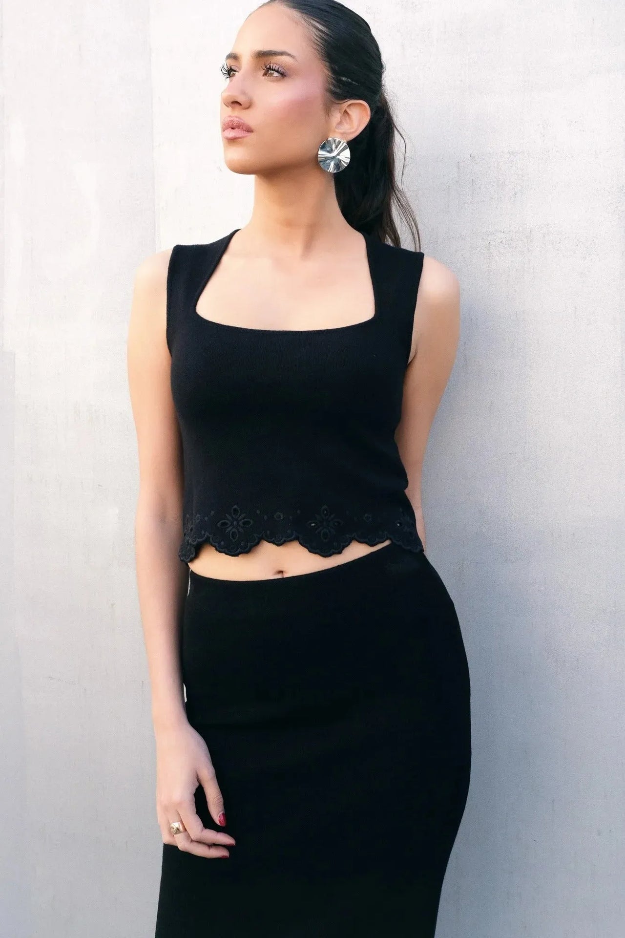 Top élégant soirée – Style minimaliste ajusté – Noir – Encolure carrée, modèle posant en noir, mettant en valeur le haut noir femme chic.