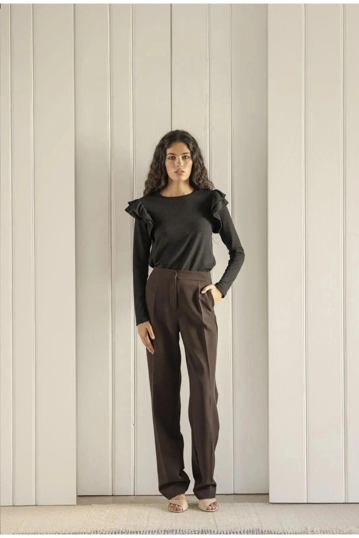 Femme portant un top en jersey à volants pour occasions spéciales et pantalon tailoring