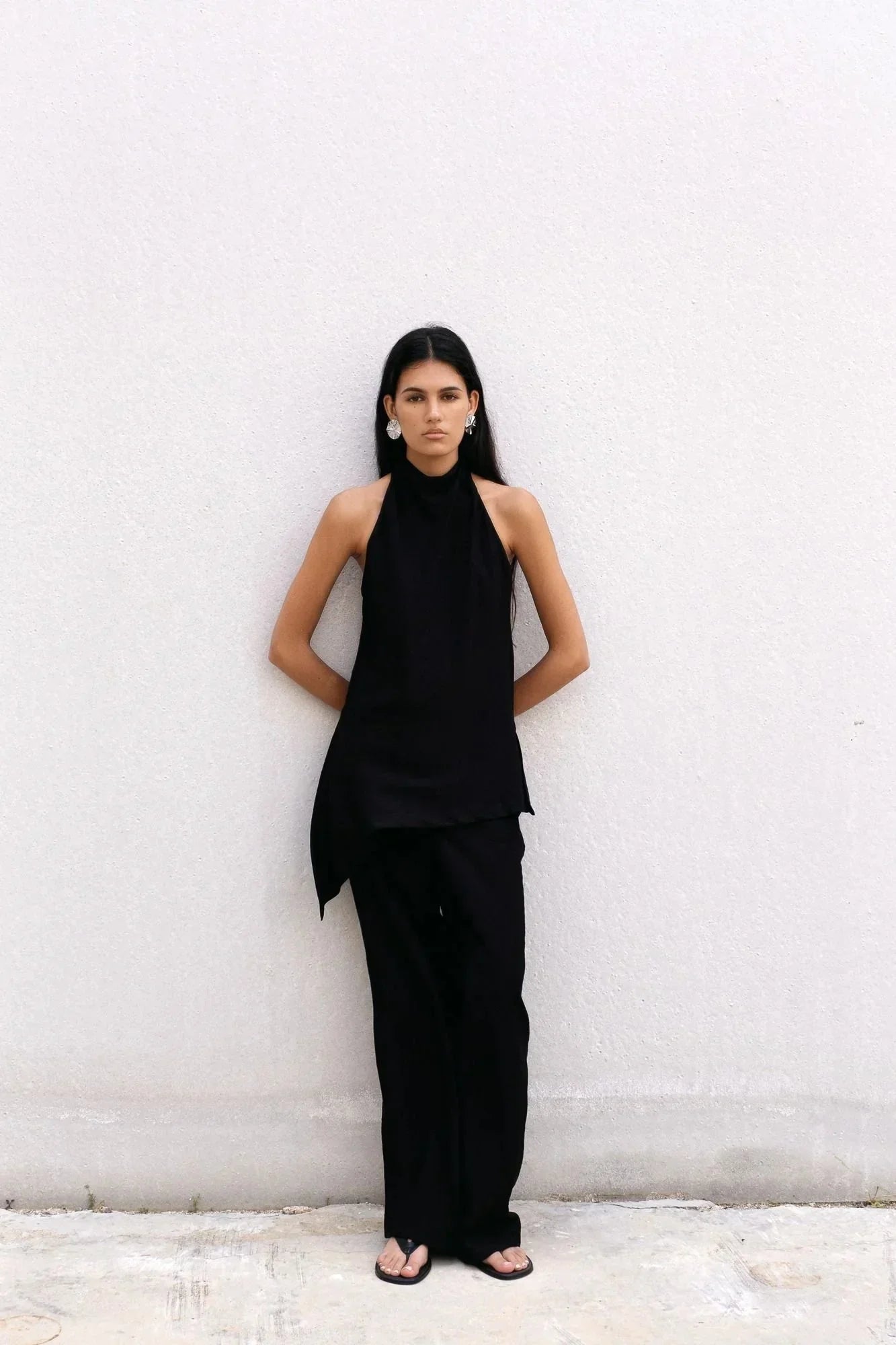 Femme portant un top halter noir et pantalon assorti, style col montant élégante