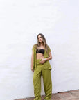 Femme portant un top kimono croisé noir, cardigan vert olive et pantalon large vert olive